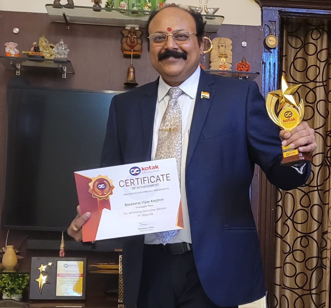Basavaraj Vijay Karjinni holding the Kotak Life Certificate of Achievement for Executive Advisor along with the accompanying star trophy.