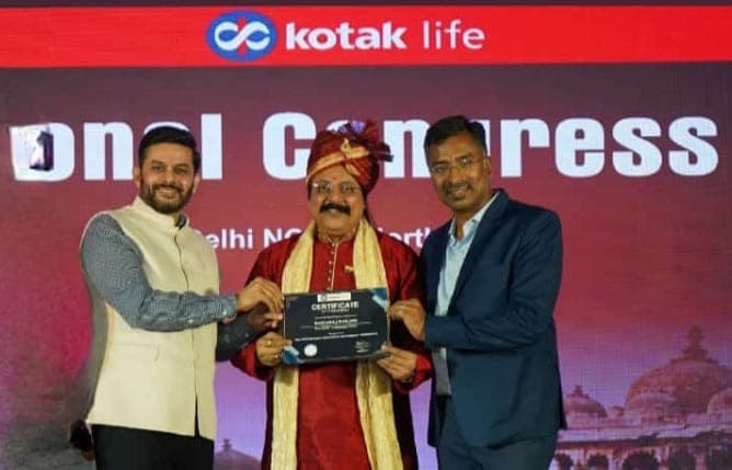 Basavaraj Vijay Karjinni receiving a certificate on stage at the Kotak Life National Congress for the Delhi NCR region.