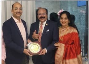 Basavaraj Vijay Karjinni receiving a Nivesh award plaque, flanked by two Nivesh representatives.
