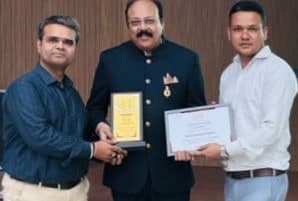 Basavaraj Vijay Karjinni receiving a Nivesh plaque and certificate from two Nivesh representatives.
